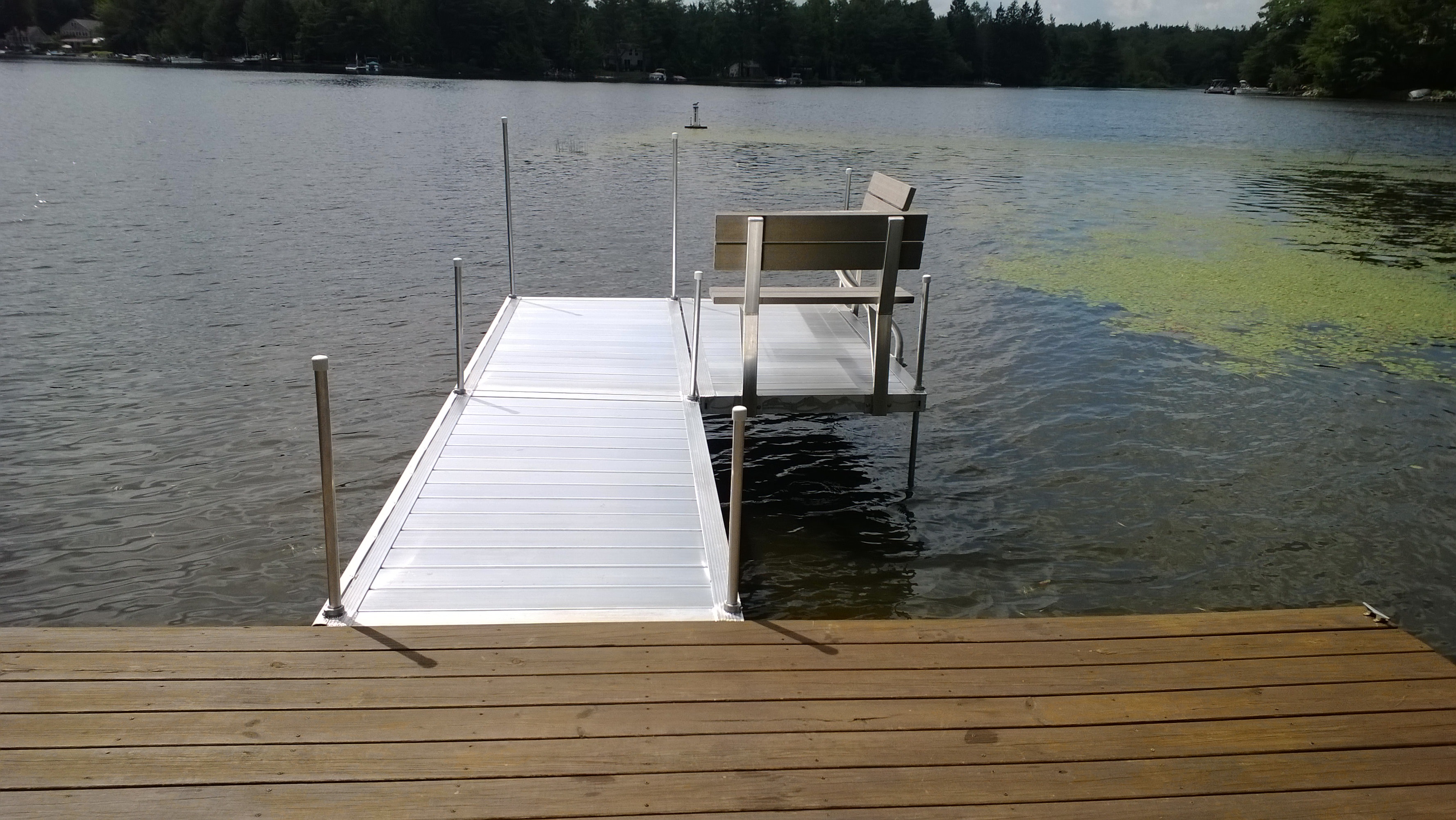 TechniDock aluminum residential dock with bench seating on a lake