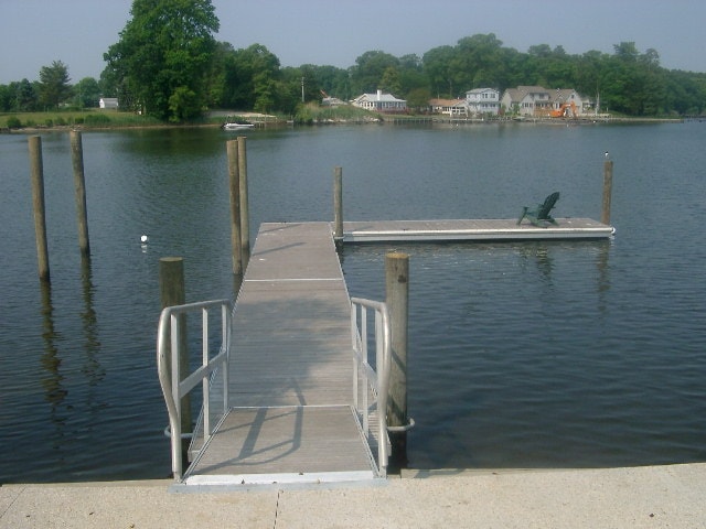 TechniDock aluminum composite dock with Adirondack chair on calm lake with residential waterfront